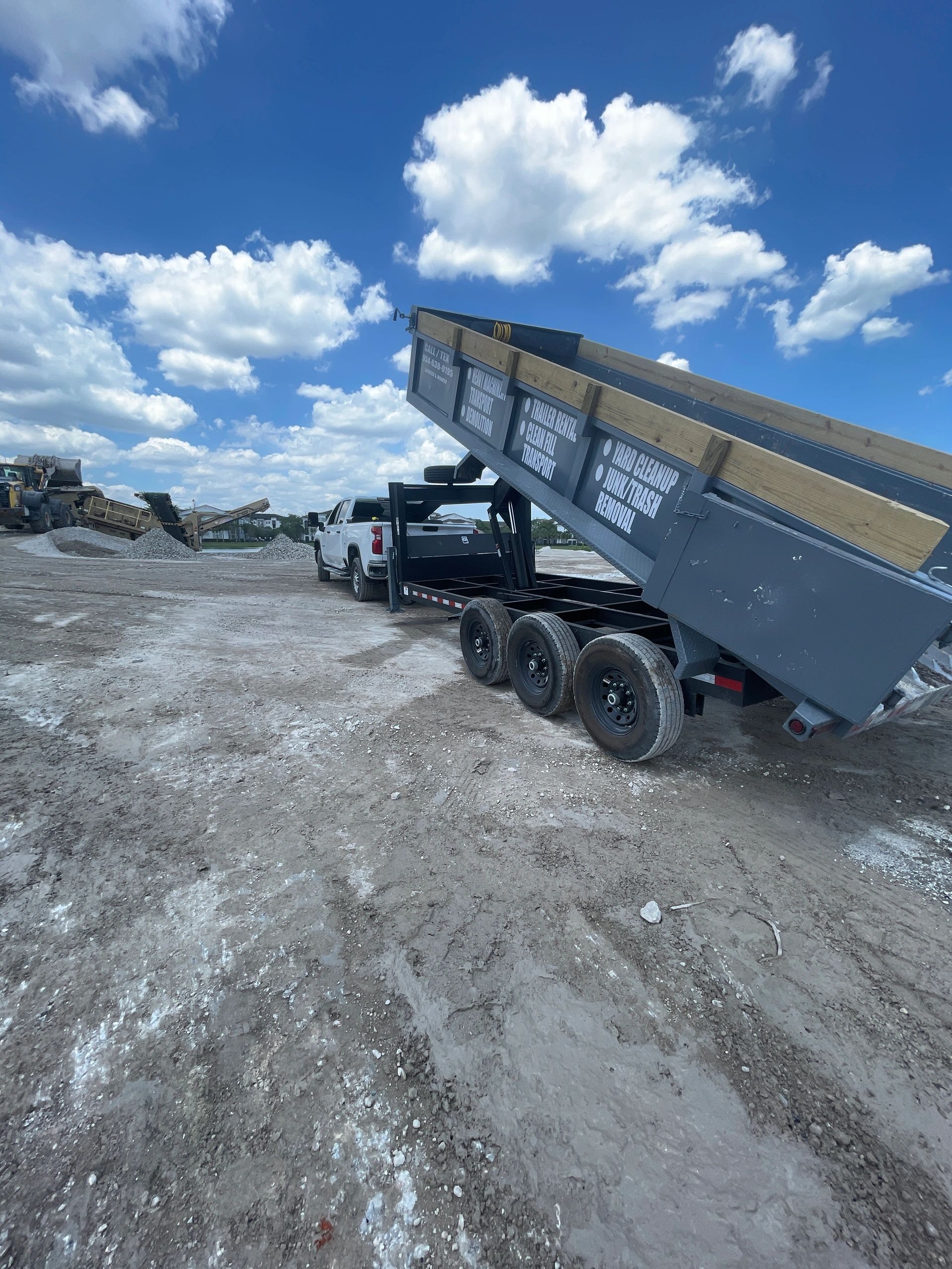 White pickup truck with dump trailer raised