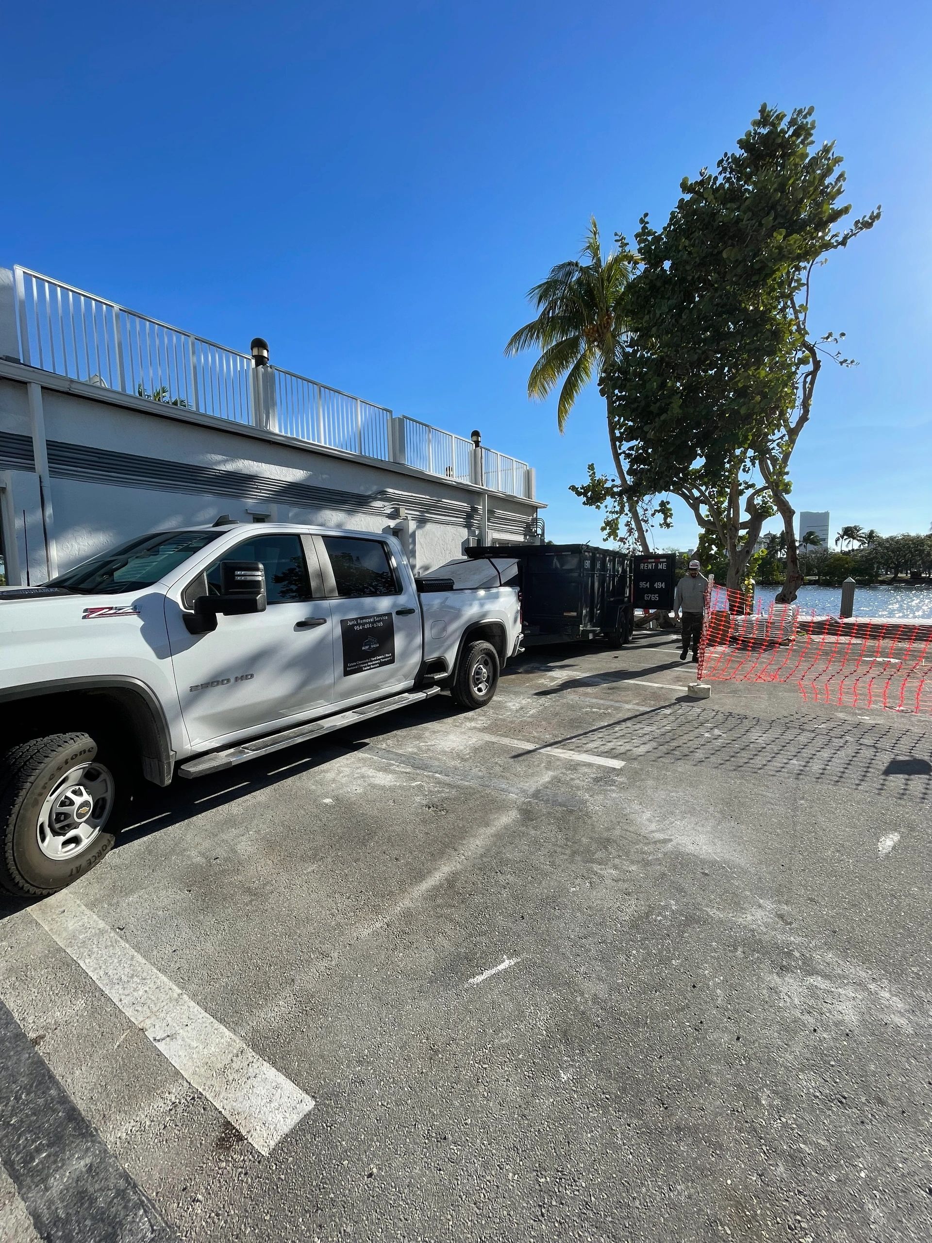 White pickup truck with utility trailer at waterfront